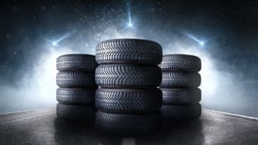 Three stacks of car tires on an asphalt road.