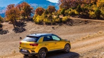 This is a gold Volkswagen T-Roc subcompact crossover SUV car on the rough roads.